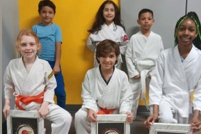 Six boy and girl students posed with three showing framed awards.